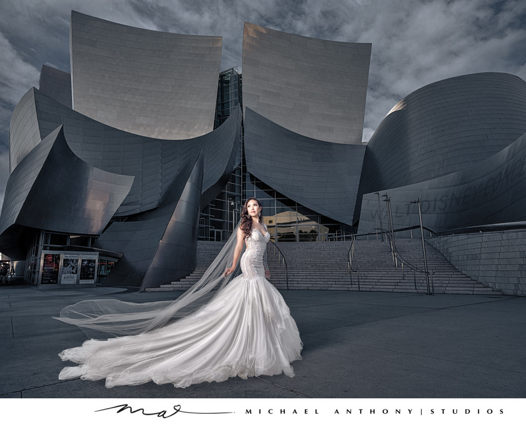 Bride poses in city in front of architectural background