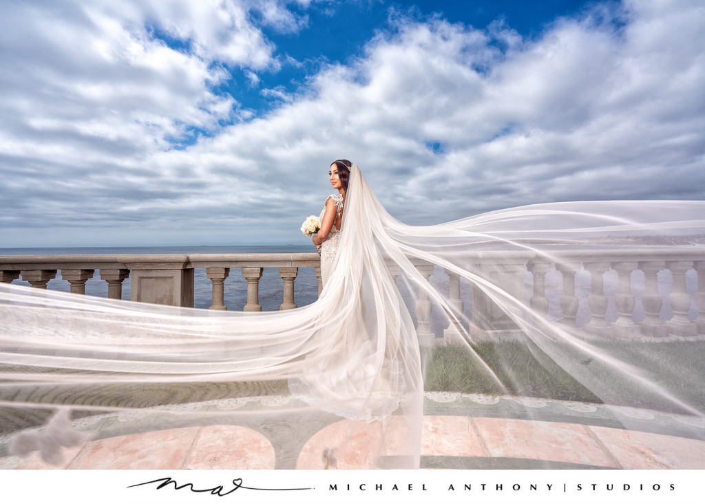 Bride posing at beach with beautiful veil