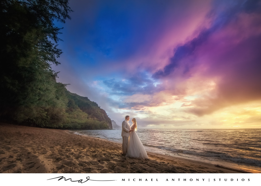 Couple poses on Hawaiian Beach at Sunset during Wedding