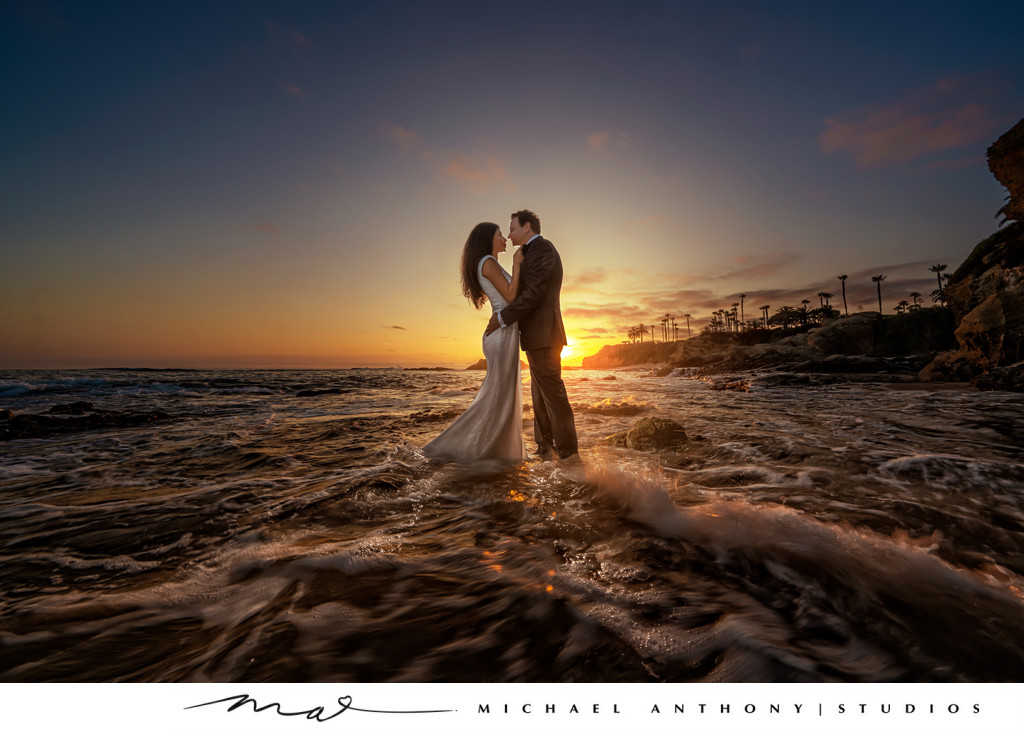 Couple standing in ocean during wedding photoshoot