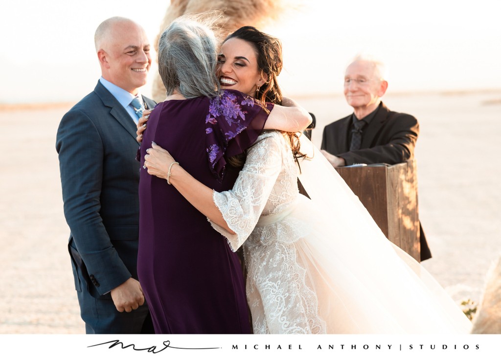 Bride hugs mother in law at ceremony