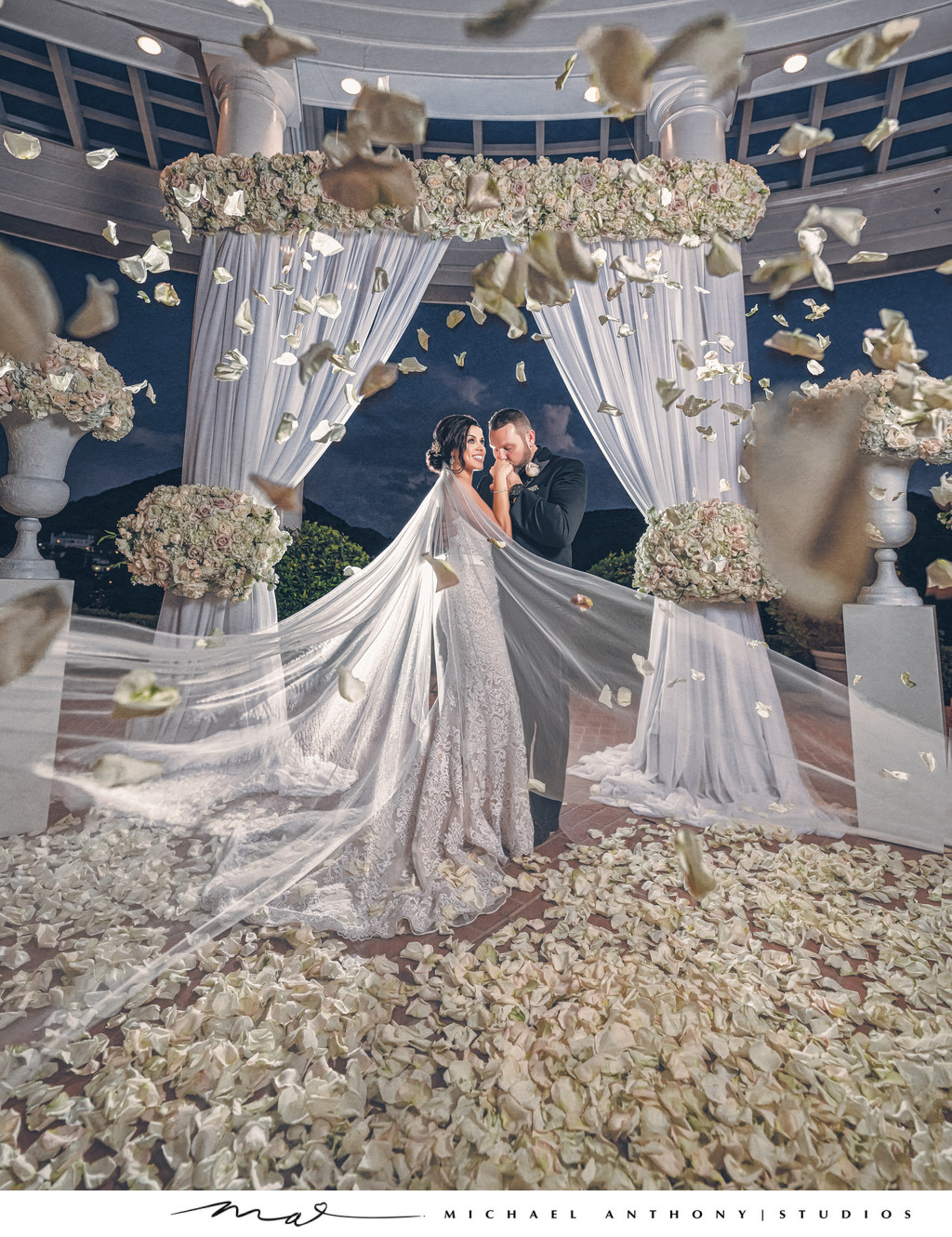 Bride and Groom in Front of Floral Archway During Ceremony