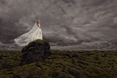 Bride Stands on Rock in dramatic bridal portrait
