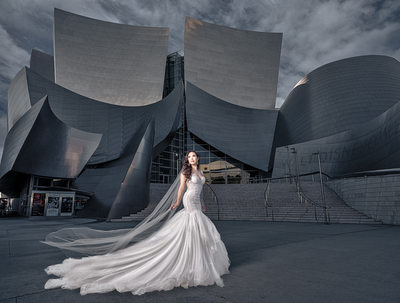 Bride poses in city in front of architectural background