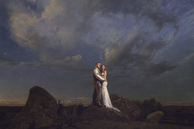 Bride and Groom pose on rock at Country Club