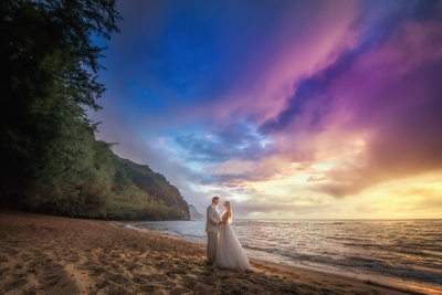 Couple poses on Hawaiian Beach at Sunset during Wedding