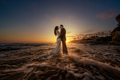 Couple standing in ocean during wedding photoshoot