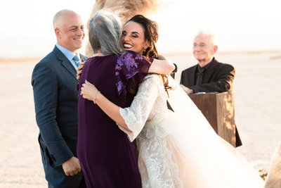 Bride hugs mother in law at ceremony