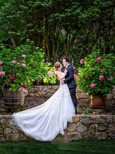 Bride and Groom Embrace in Garden Setting