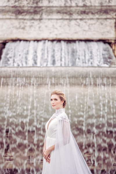 Bride standing in front of waterfall