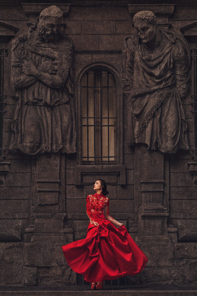 Bride in Red Wedding Dress Twirls Under Statues