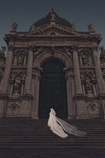 Bride poses on steps of Cathedral in Venice.