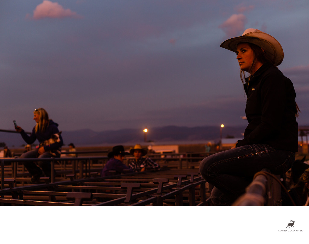 Cowgirl watches Hamilton Rodeo at Sunset