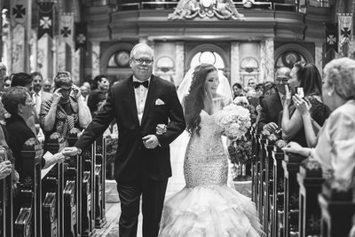 father and bride walk down the aisle at Our Lady of Victory Basilica
