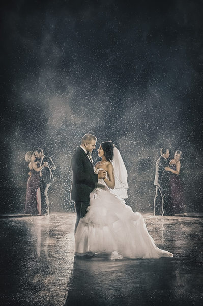 Bride and groom dance in the rain with wedding party antonios in niagara falls