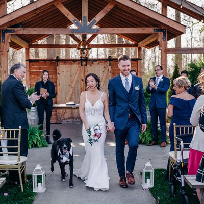Newly weds and their dog walk the isle at club roma