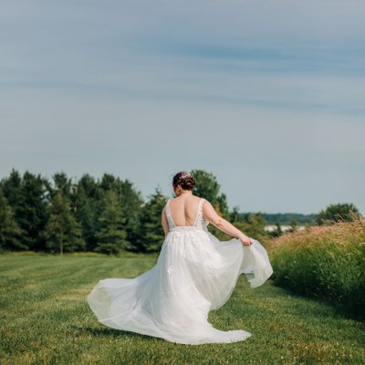 beautiful bride twirling in country field in alma