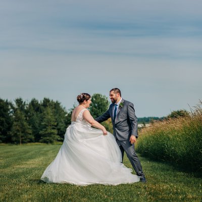 beautiful bride and groom dance in countryside field