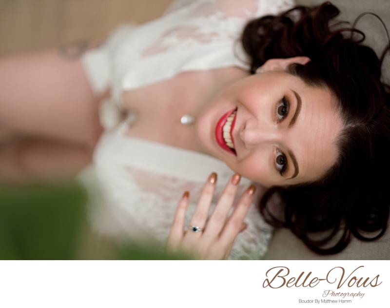 Laughing woman in lace during boudoir shoot