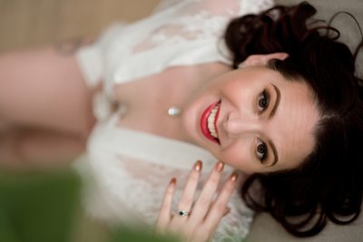Laughing woman in lace during boudoir shoot