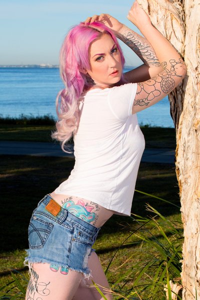 Model With Pink Hair Posing Next To Tree