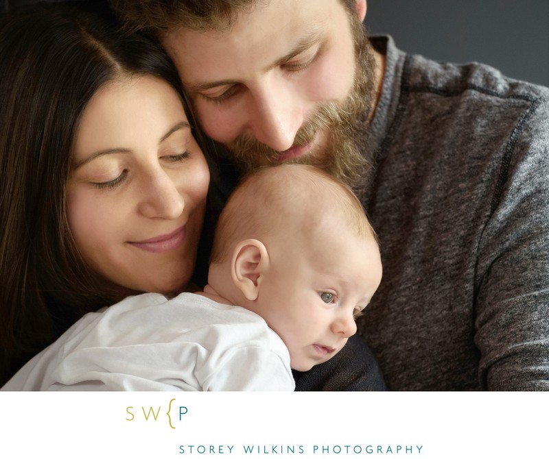 Parents Cuddle with their Newborn Baby during Session