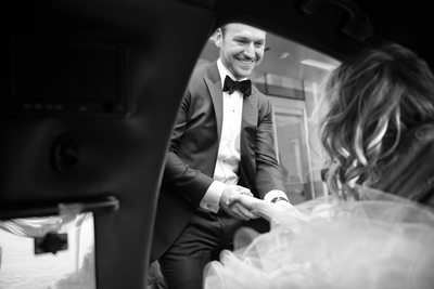 Groom Helps Bride from Car as they Arrive at Reception