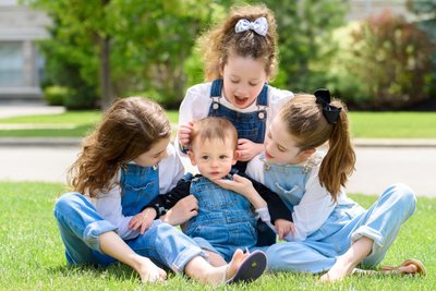 Baby Brother Surrounded: Sisters' Love on the Lawn