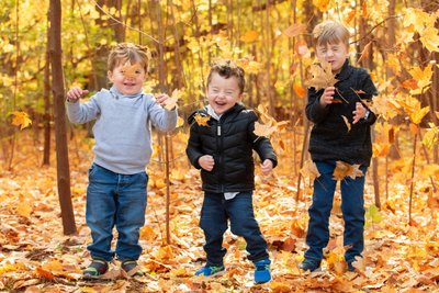 Cousins Playing in Fall Leaves Portrait