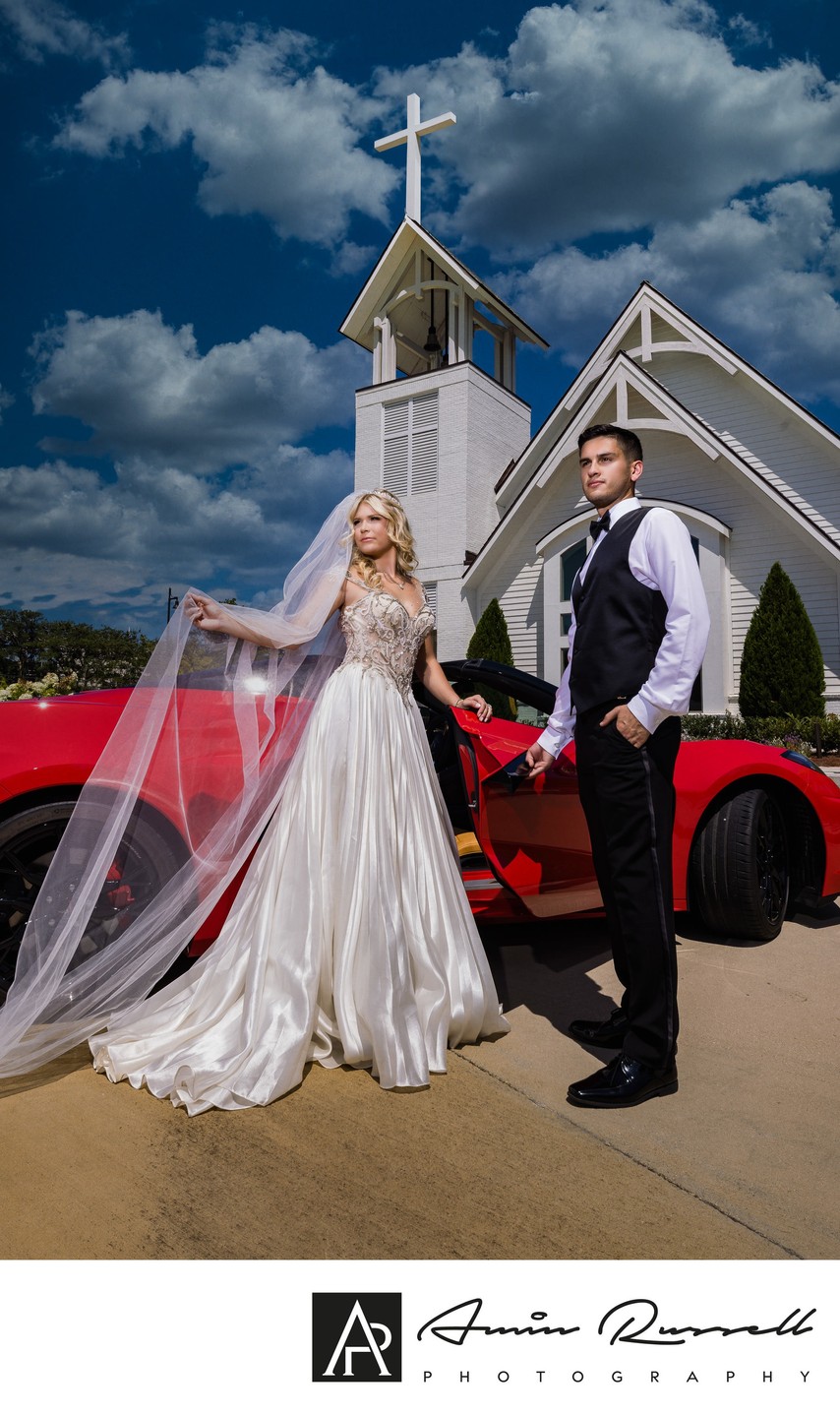 Dramatic wedding couple with red corvette