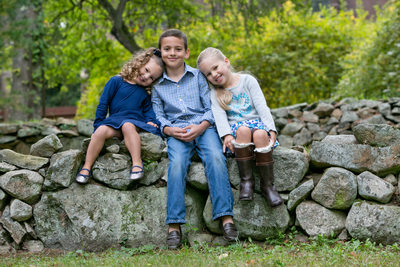siblings posed together on a stone wall