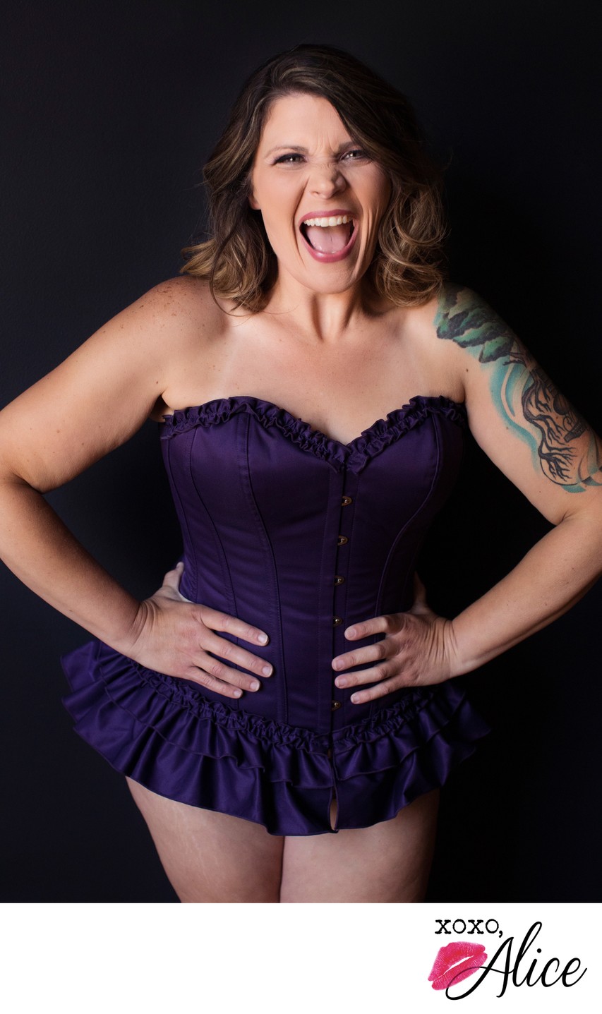 Happy woman wears purple steel boned corset for boudoir