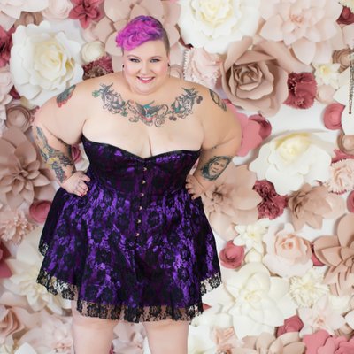 Plus sized beauty wearing a purple corset dress 