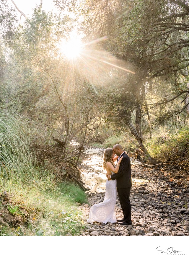 Bride and Groom by a stream at sunset