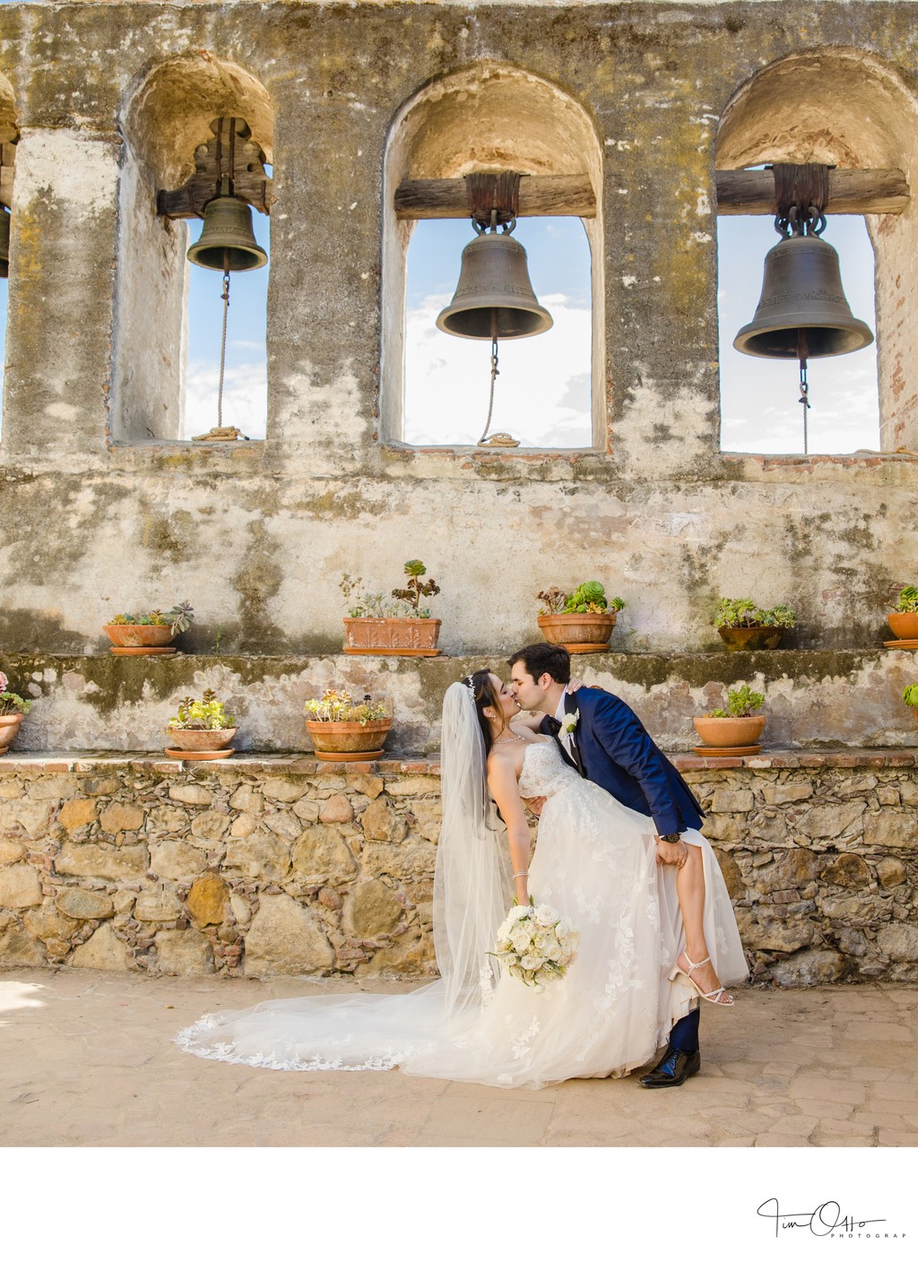 bride and groom dip at the mission san juan capistrano