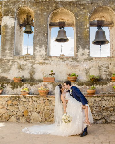 bride and groom dip at the mission san juan capistrano