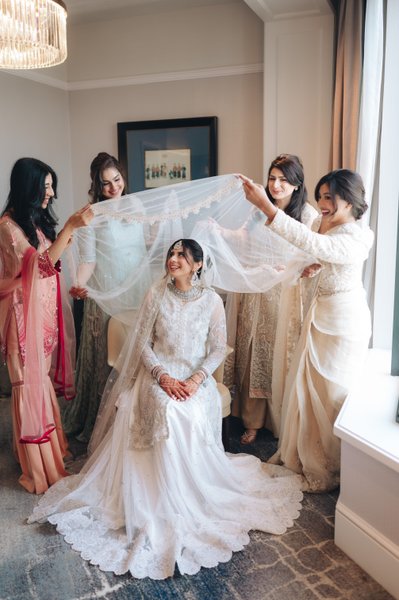  Shafia in an intricate white bridal gown getting ready at the Four Seasons Hotel with her sisters.