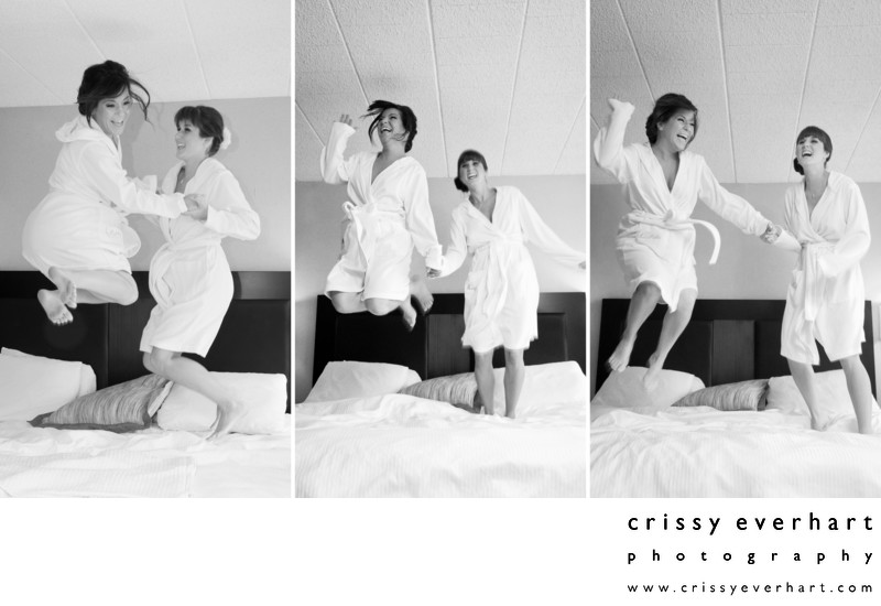 Bride and Sister Jumping on Hotel Bed in Bathrobes