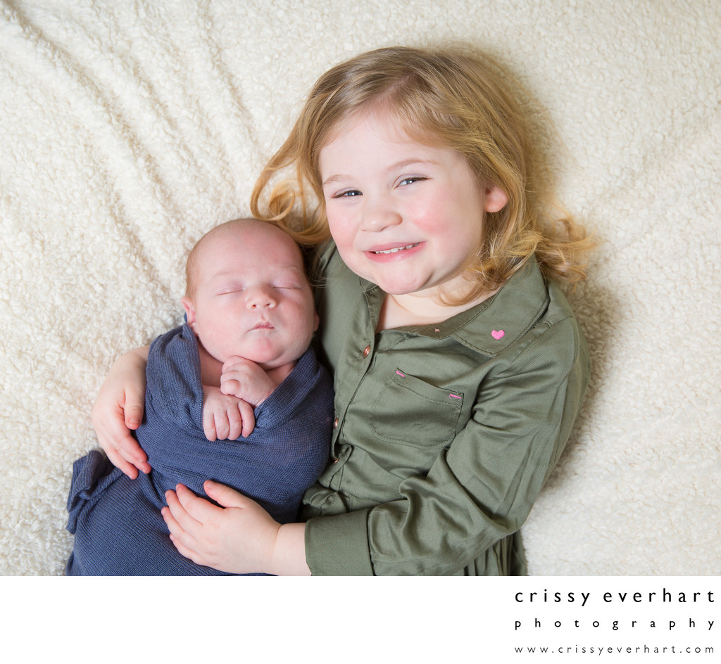 Proud Big Sister Holds Newborn Baby Brother