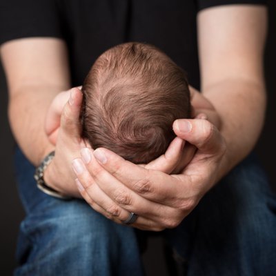 Newborn Photo of Baby in Dad's Hands - Baby Hair