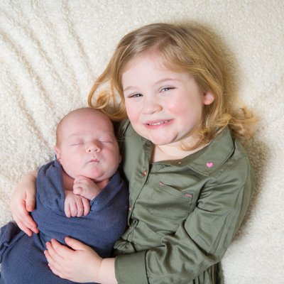 Proud Big Sister Holds Newborn Baby Brother