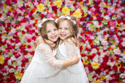 Twin Flower Girls in Front of Flower Wall