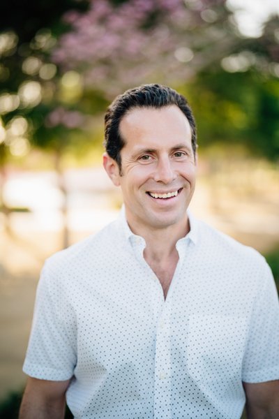 Real estate agent headshot, natural light, warm smile