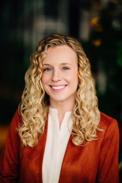Studio headshot, natural light, warm modern outfit
