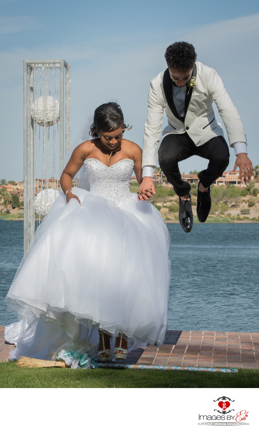 Reflection Bay Las Vegas Wedding Photography | Vegas Wedding Photos | Groom Jumping Over the Broom During Reflection Bay Las Vegas Wedding Ceremony | Images by EDI