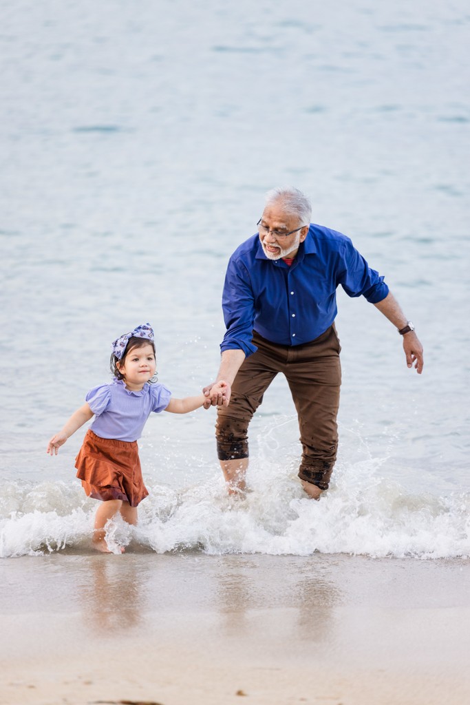 Grandfather toddler waves Tryall Club beach Jamaica