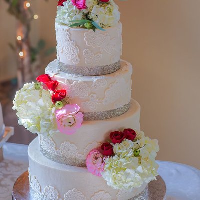 Elegant Four-Tiered Wedding Cake with Floral Accents