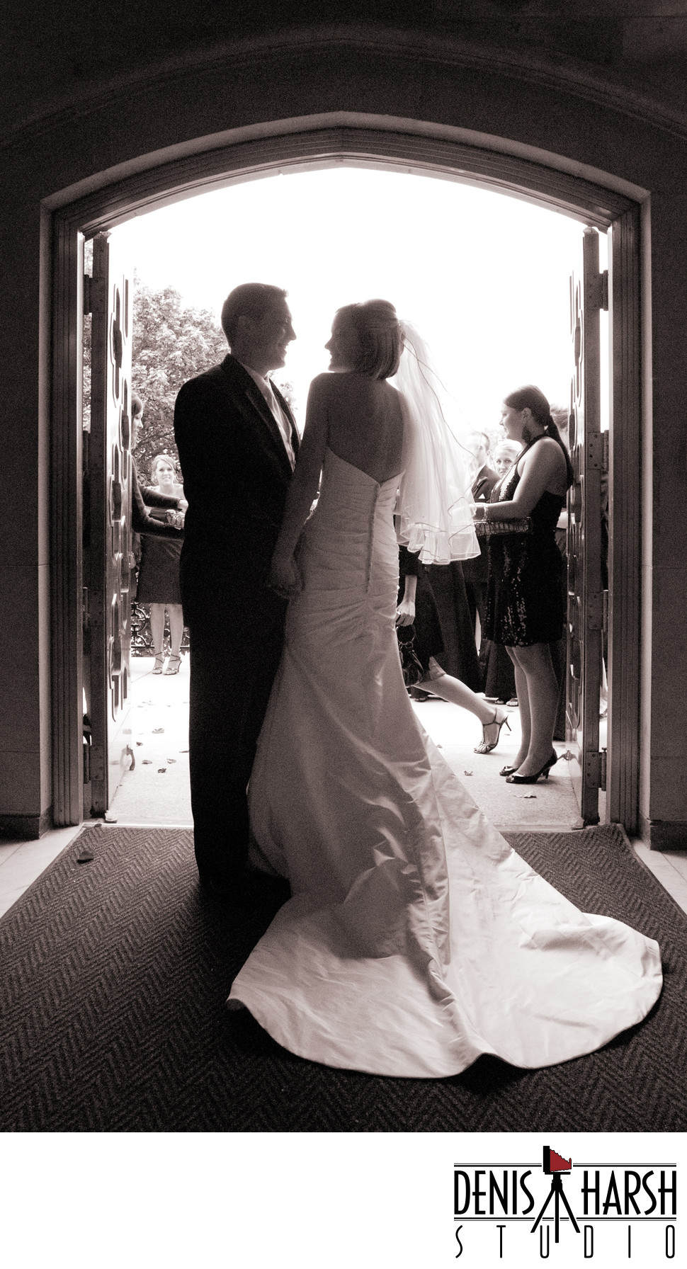 Bride & Groom silhouetted in doorway, Guests await exit