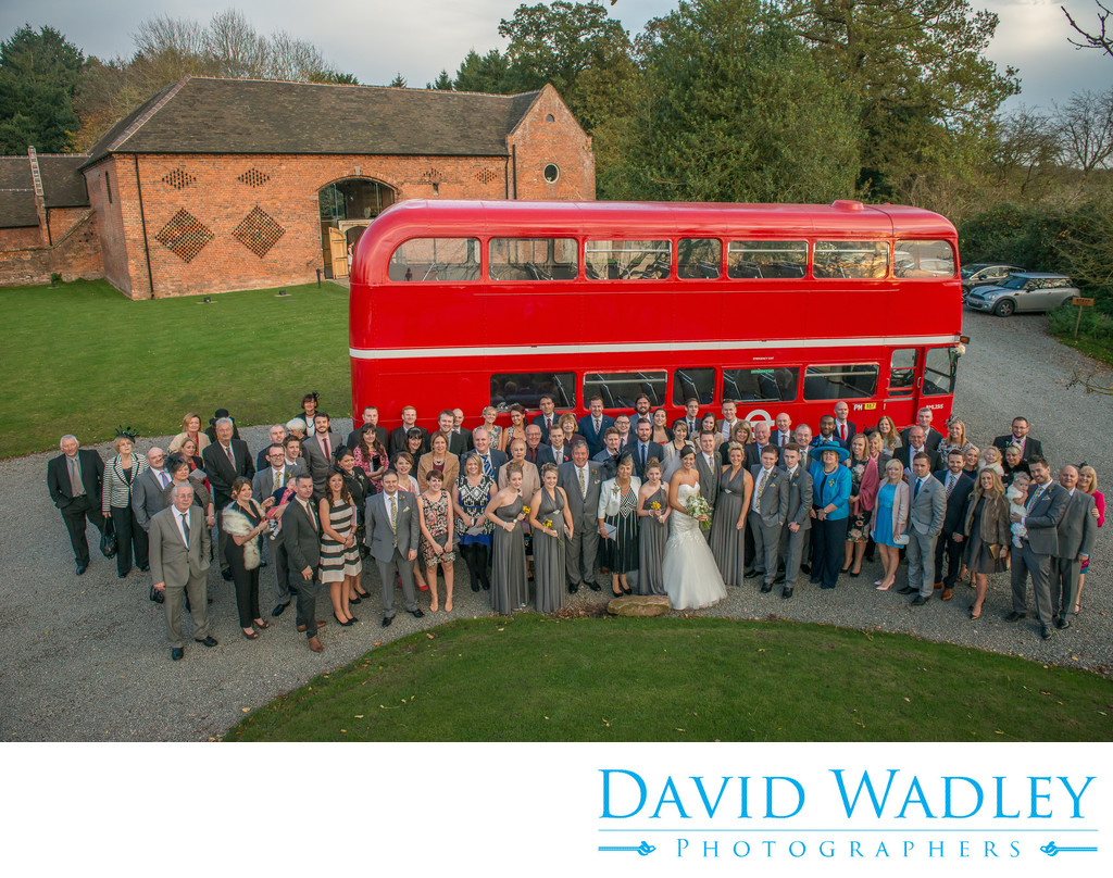 Bride & Groom with all their wedding guests photographed outside stunning Shustoke Barns.