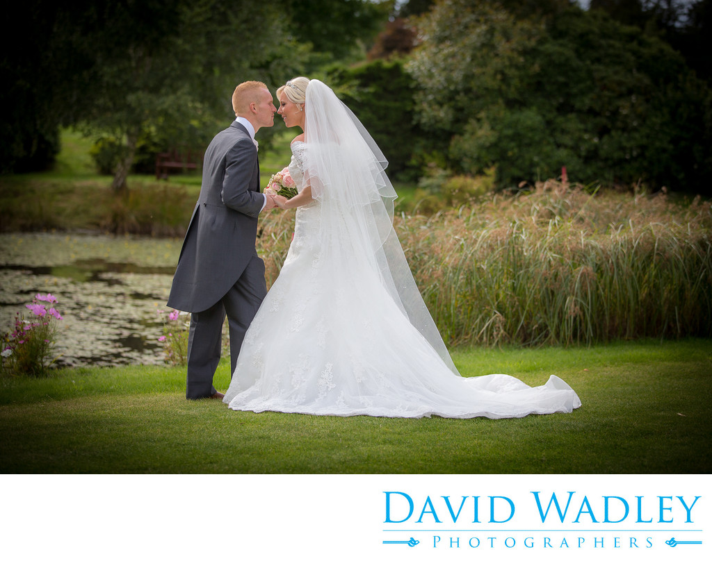 Kissing the bride in the lovely gardens of Nailcote Hall.